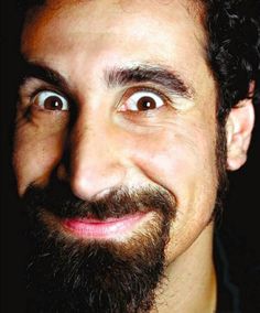 a man with curly hair and beard smiling at the camera