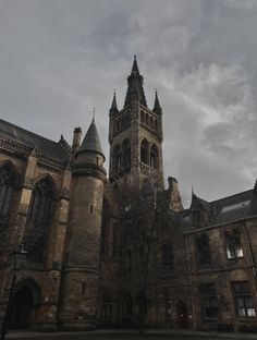 an old building with a clock tower on the top and two spires above it