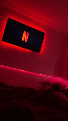 a red light is shining on the wall above a bed in a room with black sheets