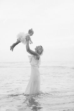 a woman holding a baby in the water