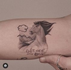 a woman's arm with a horse tattoo on it and the words get off my back written in cursive writing