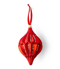 a red ornament hanging on a white wall