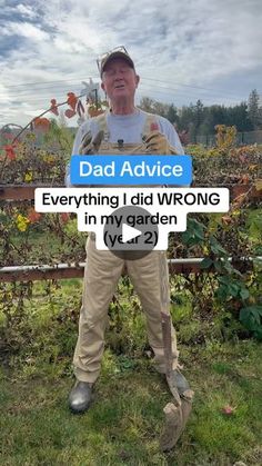 a man standing in front of a fence holding a sign that says dad advice everything i did wrong in my garden