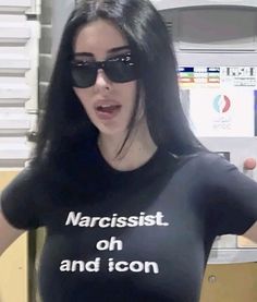 a woman with sunglasses on her head wearing a t - shirt that says narcisst oh and icon