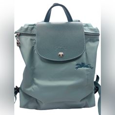 This Mini Backpack Handbag Is Known For Its Clean Lines And Ultra-Lightweight Materials. Soft And Foldable With Adjustable Straps, This Accessory Is An Example Of Truly Contemporary Design. The Bag Follows Strong Codes, Like The Horse Embroidery, And Has Tone-On-Tone Russian Leather Trimmings Characteristic Of Longchamp. The Ultimate Detail: A Green Edge On The Ear, Indicative Of Its Environmentally-Sound Use Of Materials While Echoing The Brand's Signature Bright Green Color, Symbolic Of Its Energy, Freshness And Dynamism! 10.25" (L) X 11" (H) X 4" (W) Recycled Polyamide Canvas With Inside Coating Silver Color Metallic Hardware Russian Leather (Cowhide) Trimming 1 Interior Flat Pocket Longchamp Le Pliage Green, Horse Embroidery, Bright Green Color, Backpack Handbag, Longchamp Bags, The Horse, Mini Backpack, Longchamp Le Pliage, Travel Backpack