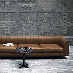 a brown leather couch sitting next to a table