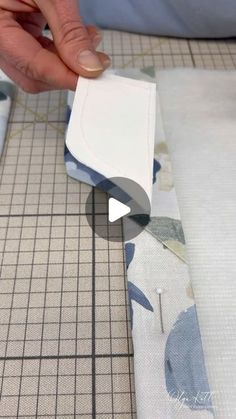 someone is cutting out some fabric with scissors and tape on the edge of a piece of cloth