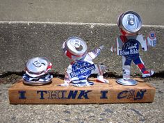 three tin cans are sitting on top of a wooden sign that says i think i can