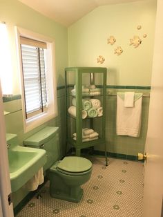 a green toilet sitting in a bathroom next to a sink