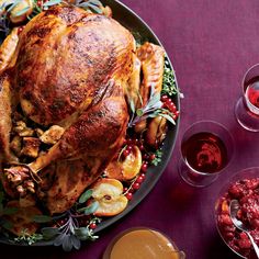 a roasted turkey on a platter with cranberry sauce and garnishes