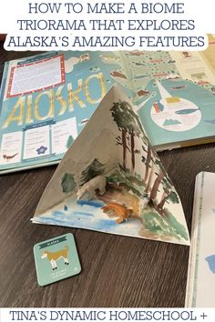 an open book sitting on top of a wooden table next to other children's books