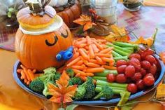 a platter filled with lots of veggies and pumpkins on top of a table