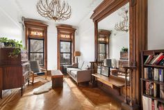 a living room filled with furniture and lots of windows next to a book shelf full of books