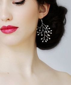 a woman with red lipstick and earrings on her face