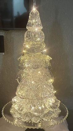 a glass christmas tree with lights on it