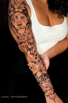 a woman with a lion tattoo on her arm and shoulder, holding onto the arm