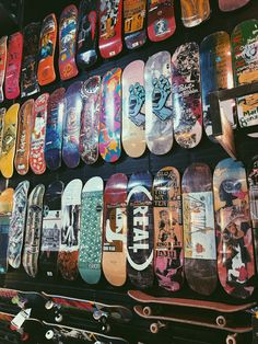 many skateboards are stacked up on the wall and ready to be used for sale