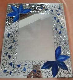 a decorative mirror with blue flowers on it