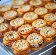 small sandwiches and crackers are arranged on a tray