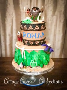 a three tiered cake with the name roma on it's side and people sitting on top