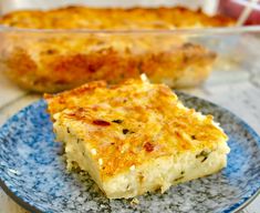 a piece of quiche on a blue and white plate next to another dish in the background