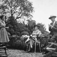 an old black and white photo of people sitting in chairs