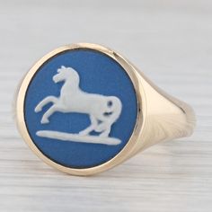 This lovely vintage wedgewood ring is features a signet style bearing a horse done in the classic wedgewood blue and white. The ring comes with a Liberty of London inner and outer box, both is great condition. This piece has a retail value of $840 so don't pass up this great deal!  Material: - Wedgewood Cameo - Size - 14.5 mm Cut - Round Color - Blue and White Metal: 9k Yellow Gold Weight: 6.6 Grams  Stamps: 375, other British hallmarks Face Height: 15 mm  Rise Above Finger: 4.5 mm Band / Shank Width: 3.3 mm This ring is a size 7 1/2, but it can be resized up 2 sizes for a $30 fee per size. If you would like your ring resized, please select the appropriate fee from the listing below in order to pay the sizing fee: https://www.etsy.com/listing/781388346/ring-sizing-service-fee Each piece is Classic Blue Hallmarked Signet Ring, Classic Hallmarked Blue Signet Ring, Classic Blue Signet Ring Stamped 14k, Vintage Blue Signet Ring, Classic Cameo Rings, Classic Blue Signet Ring For Wedding, Classic Blue Round Engraved Ring, Antique Blue Hallmarked Signet Ring, Classic Blue Engraved Round Ring