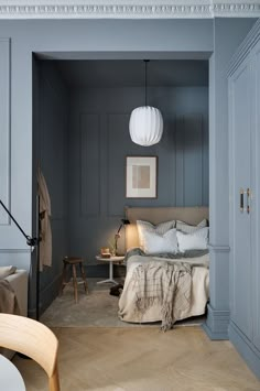 a bedroom with blue walls and wooden floors