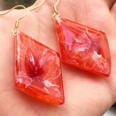 a pair of red earrings with flowers on them