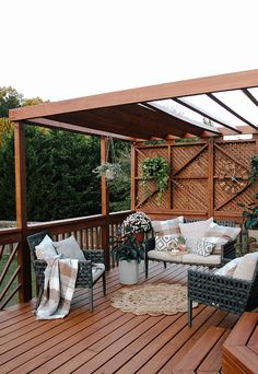 a wooden deck with wicker furniture and potted plants