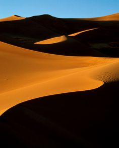 the sun is shining on some sand dunes