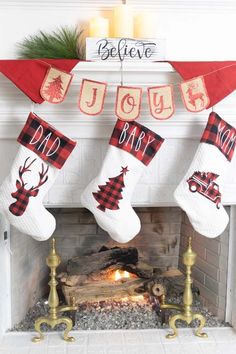 christmas stockings hung over a fireplace with the words joy, baby and dad written on them