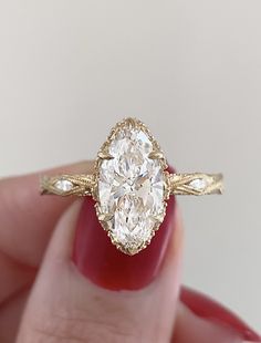 a close up of a person holding a ring with a diamond in it's center