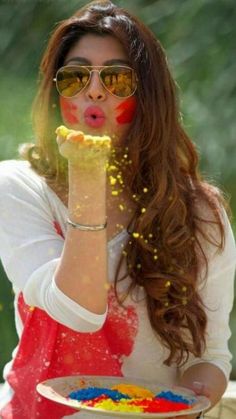 a woman wearing sunglasses and eating food out of a bowl