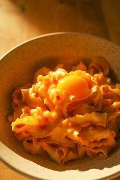 a bowl filled with macaroni and cheese on top of a wooden table