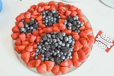 a cake with berries, blueberries and raspberries in the shape of a heart