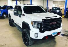 a white truck parked in a garage next to other trucks