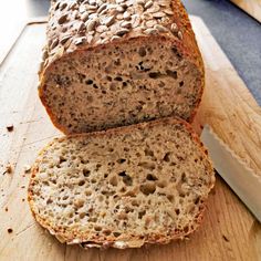 a loaf of bread with raisins on it next to a knife