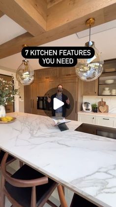 a man standing in front of a kitchen counter with the words 7 kitchen features you need