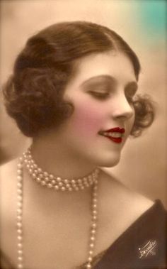 an old fashion photo of a woman with pearls on her necklace and red lip ring