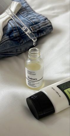 an open bottle of eye cream next to a pair of jeans