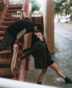 a man and woman kissing on the stairs