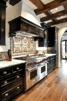 a kitchen with black cabinets and white counter tops, wood flooring and an ornate tile backsplash