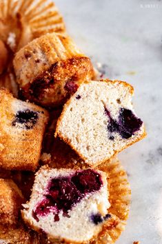 some blueberry muffins are sitting on a plate with other muffins