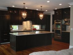 a large kitchen with dark wood cabinets and stainless steel appliances