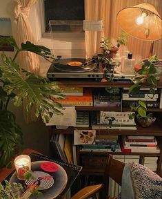 a record player sitting on top of a wooden table next to a potted plant