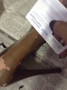 a person holding a pair of scissors on top of a piece of paper that has been torn off