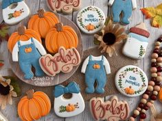 decorated cookies with baby's first names and pumpkins on the table next to them