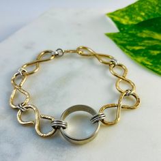 "After receiving quite a bit of interest in the bracelet I created to house my late husband's wedding band so that I could wear it daily, I decided to start offering this option to those of you who wish to do the same! Thick wire is hand molded into infinity links and hammered to catch the light and give this beautiful bracelet some depth.  Your loved one's band will be securely linked into the center of the bracelet. Note: I can only use bands in this style of bracelet.  If they have stones, th Gold Bracelet With Decorative Band As Gift, Classic Bracelets With Decorative Band As Gift, Gold Bracelets With Decorative Band As Gift, Gold Bracelet With Decorative Band For Anniversary, White Gold Round Band Bracelets For Anniversary, White Gold Round Band Bracelet For Anniversary, 14k Stamped Bangle Bracelet For Anniversary, Anniversary White Gold Oyster Bracelet Jewelry, Adjustable Heirloom Bracelets For Anniversary