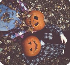 two pumpkins sitting on the ground with faces carved into them